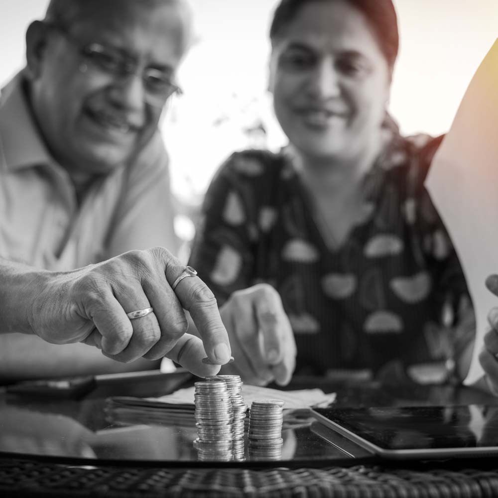 Portrait of Indian Senior Couple Putting Penny-By-Penny on a Table at Scout Advocacy