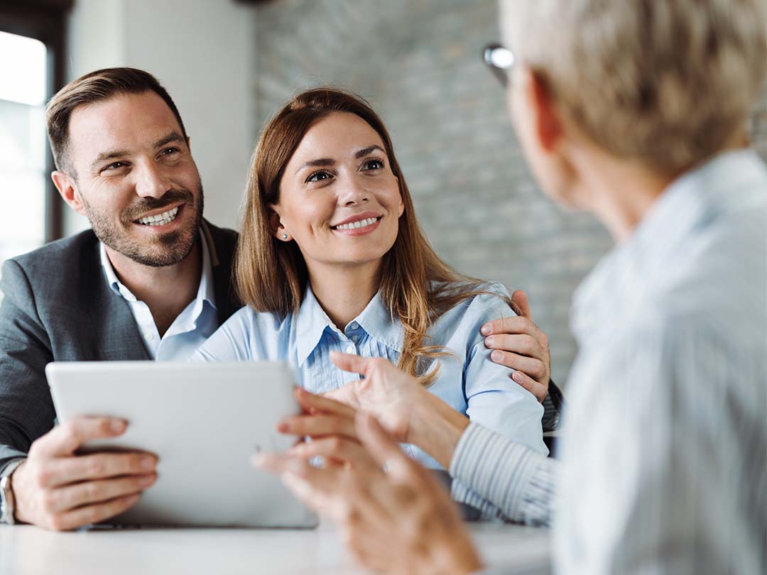 Couple in their thirties listening to elderly advisor